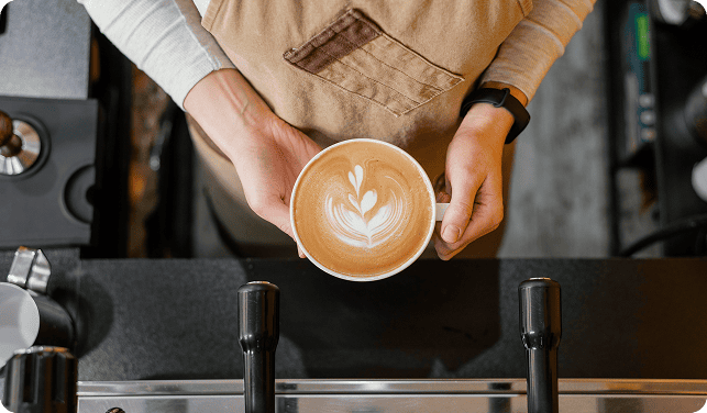 Barista holding a latte at the Park + Coffee counter